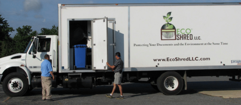 Eco-Shred Mobile Shredding Truck with two individuals standing next to it operating the shredding function.